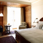 Bed and balcony seating nook in the Deluxe Greenwich room at The Greenwich Hotel New York