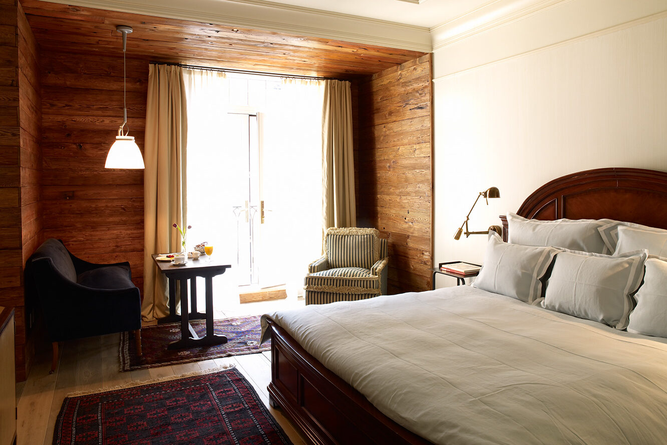 Bed and balcony seating nook in the Deluxe Greenwich room at The Greenwich Hotel New York