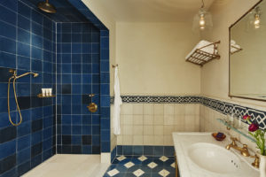 Superior King room shower, blue and white tile and sink at The Greenwich Hotel