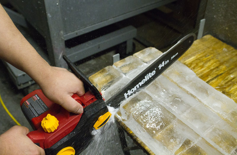 Cutting a block of ice with a chainsaw at Weather Up Cocktail Bar