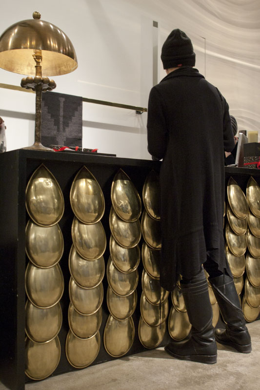 A man stands at the Patron of the New customer service counter with brass decorative front