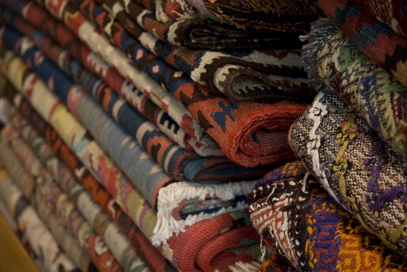 Stacks of intricate folded rugs at Double Knot