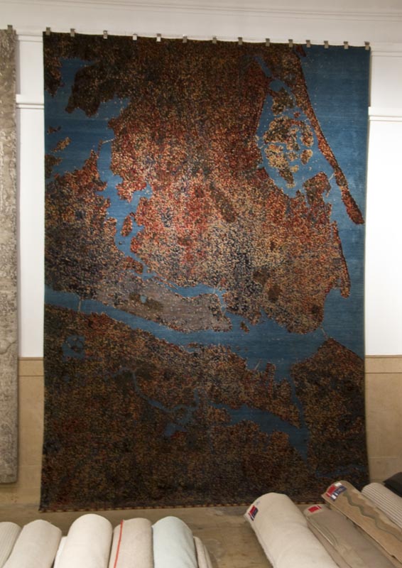 A copper and blue rug hanging on the wall in Carini Lang