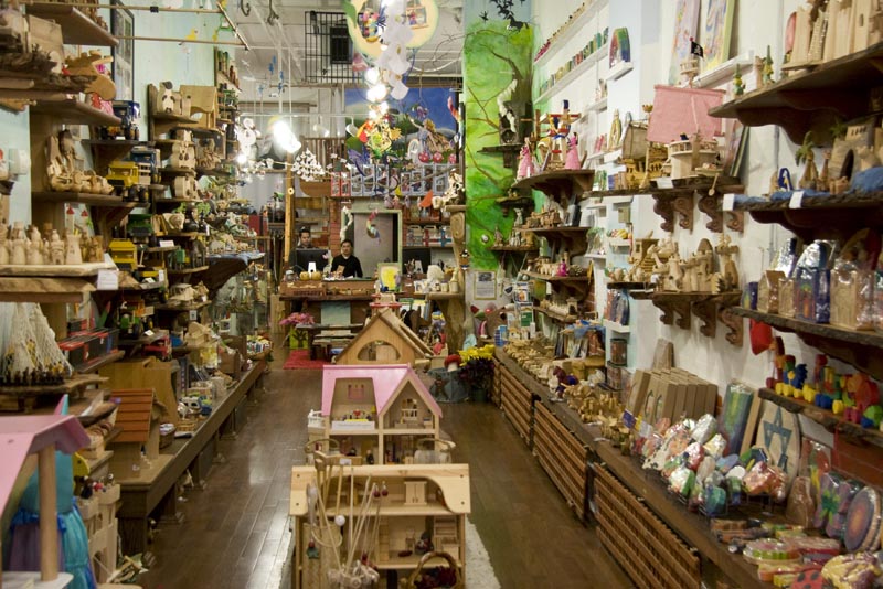 A wide view of an aisle of toys for sale inside Playing Mantis Toys and Crafts