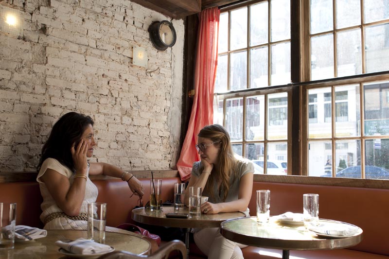 Two women dine in a corner of Tiny's and the Bar Upstairs