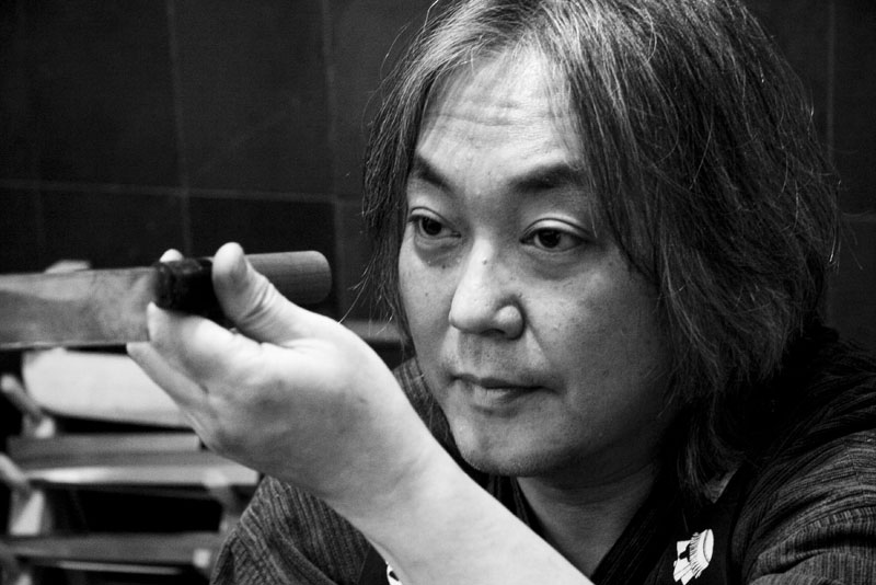 Chiharu Sugai examining a knife at Korin Japanese Trading, Corp