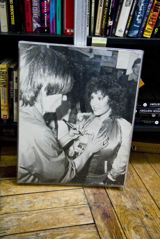 A photograph of Iggy pop signing his fans chest at the Archive of Contemporary Music