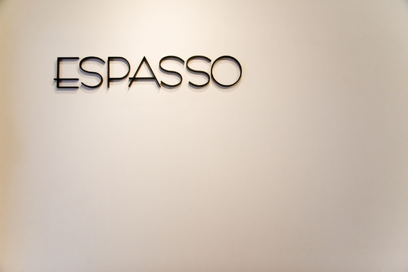 Espasso logo typography on a white wall