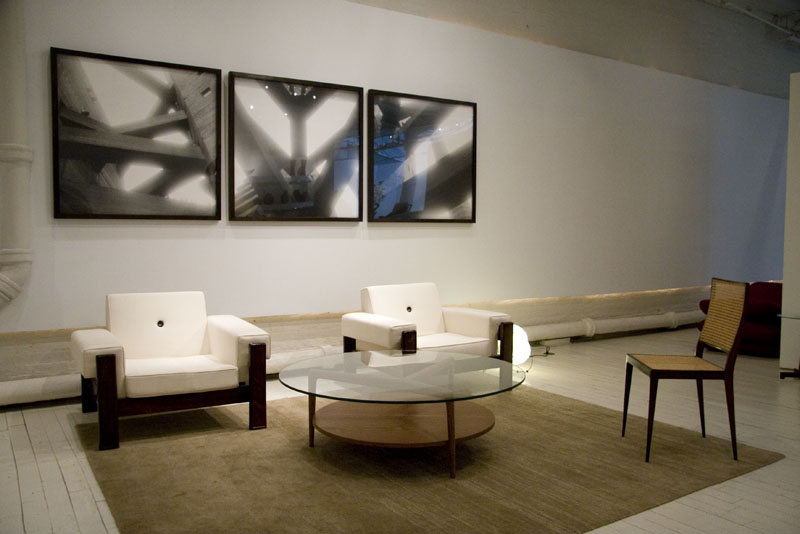 White armchairs, a triptych of art on the wall and circular glass coffee table in the Espasso showroom