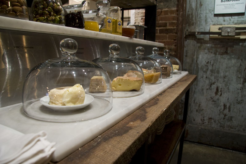 A lineup of cheese under glass at Terroir Wine Bar
