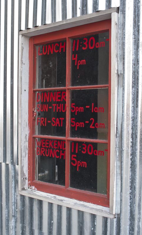 Hours of operation written on the window at Warren 77