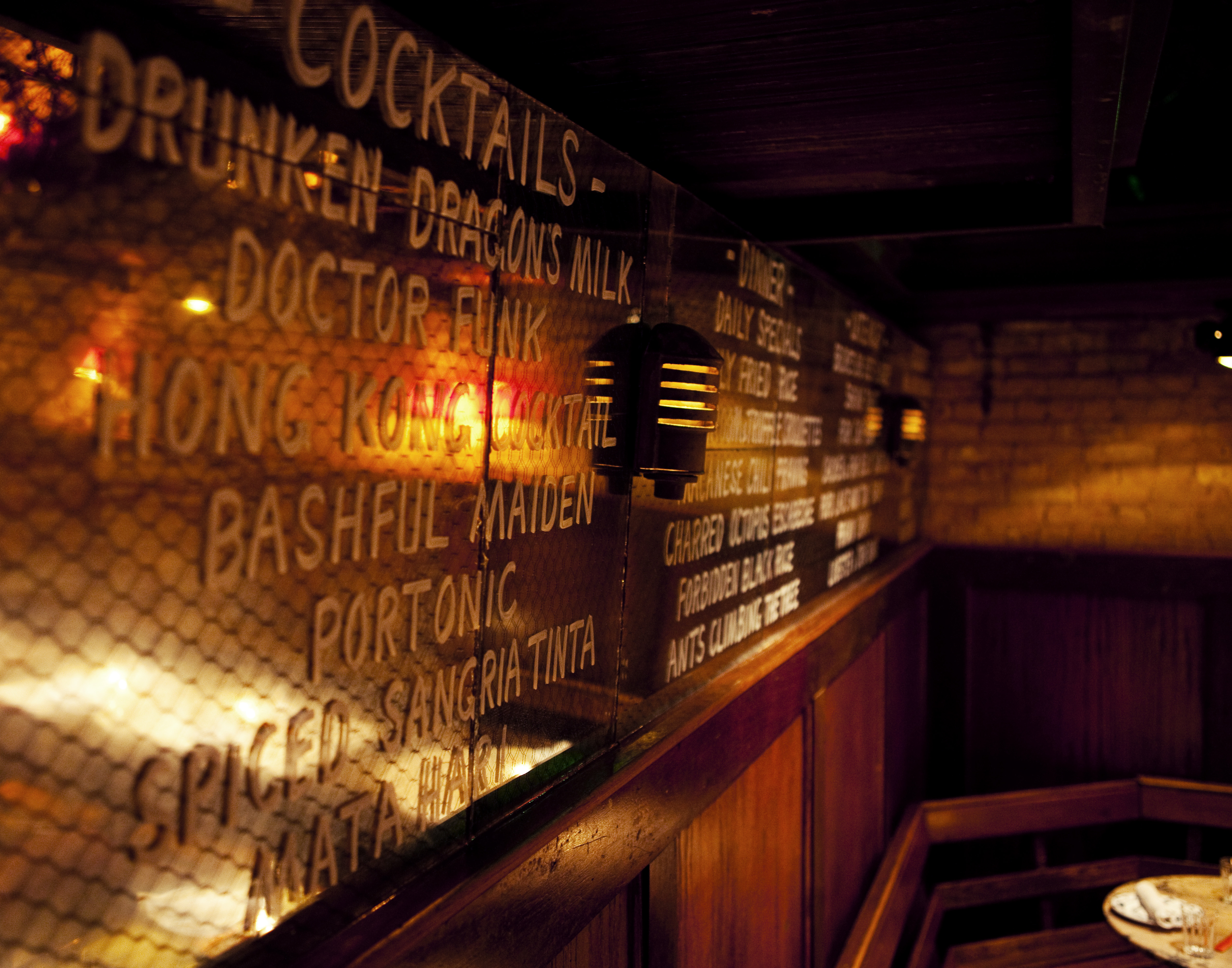 Cocktail list painted on the mirrored glass inside Macao Trading Co.