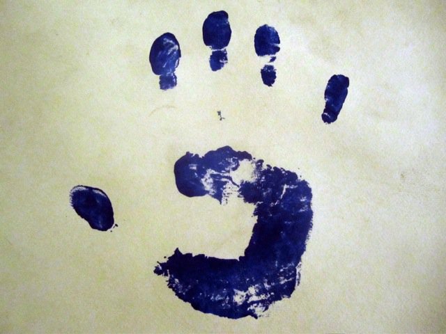 A close up of a black ink handprint from Clocktower Gallery