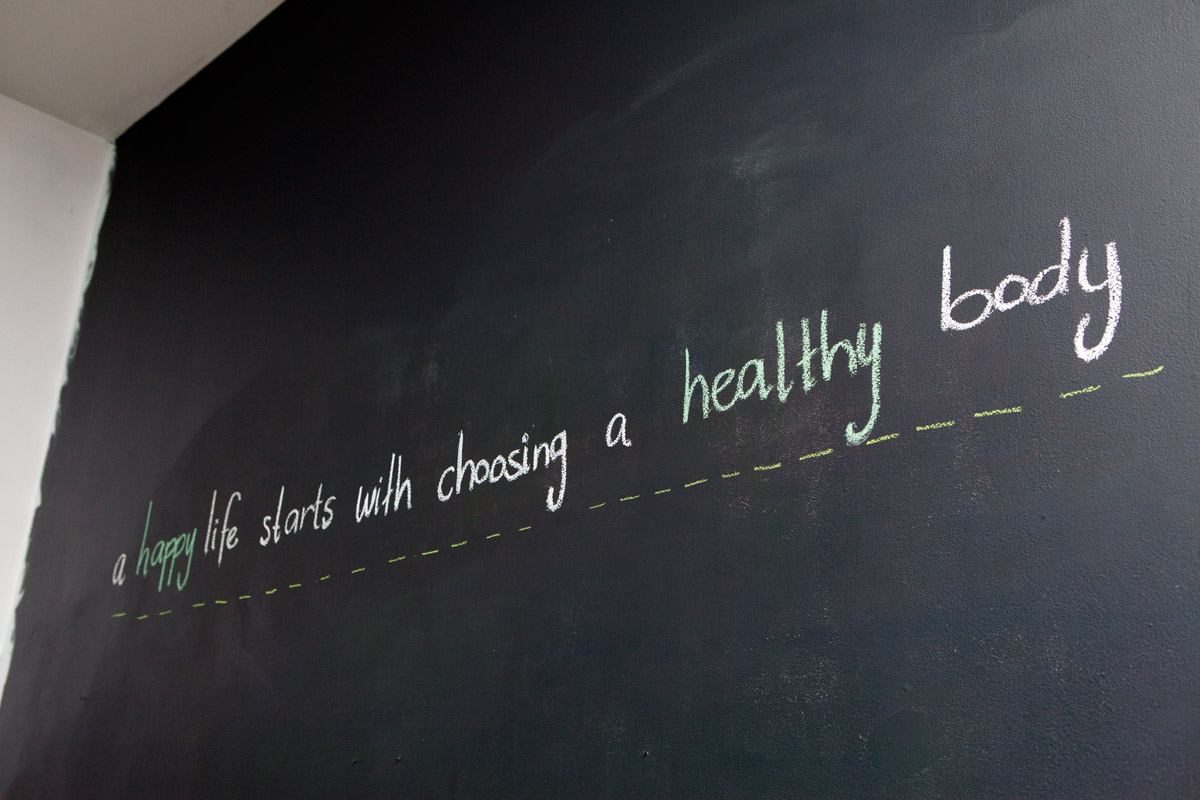 A Bari chalkboard wall with the message a happy life starts with choosing a healthy body