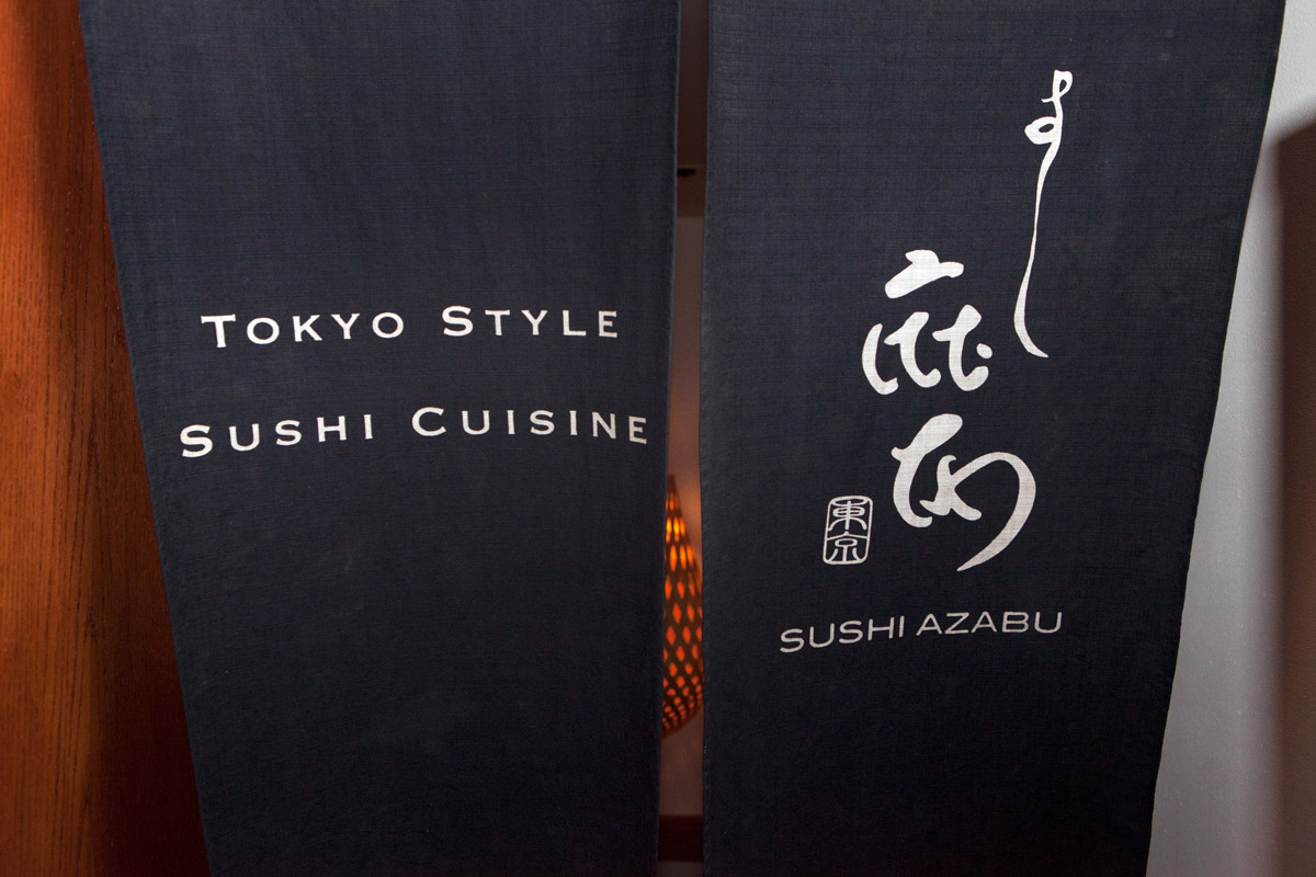 Close up of Sushi Azabu logo and Tokyo style sushi cuisine on black fabric