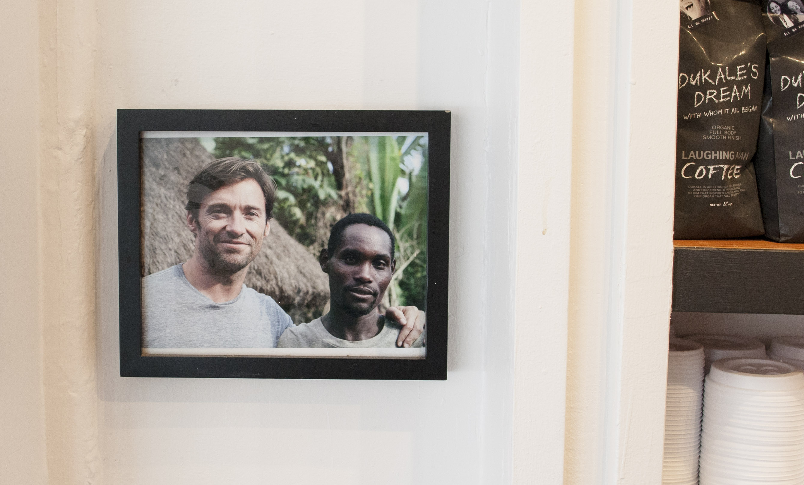 Framed photo of Dukale, a coffee farmer in Ethiopia, and actor Hugh Jackman on the Laughing Man wall