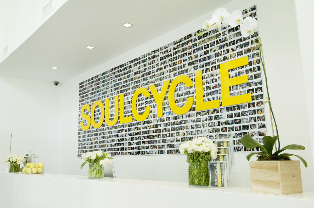 Soulcycle logo and mural on a white wall inside the studio