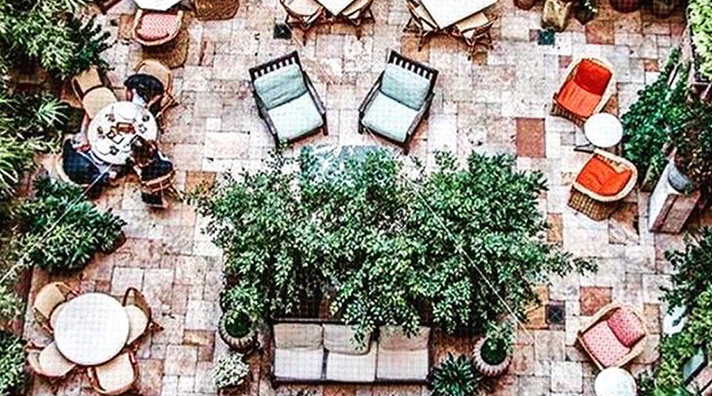 An aerial view of an outdoor seating area with tables, chairs, and trees.