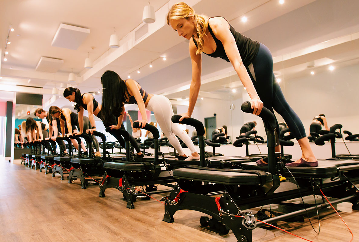 Group of women using the pilates equipment