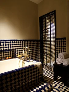 Walk-in shower door and soaking tub wrapped in blue and white tile