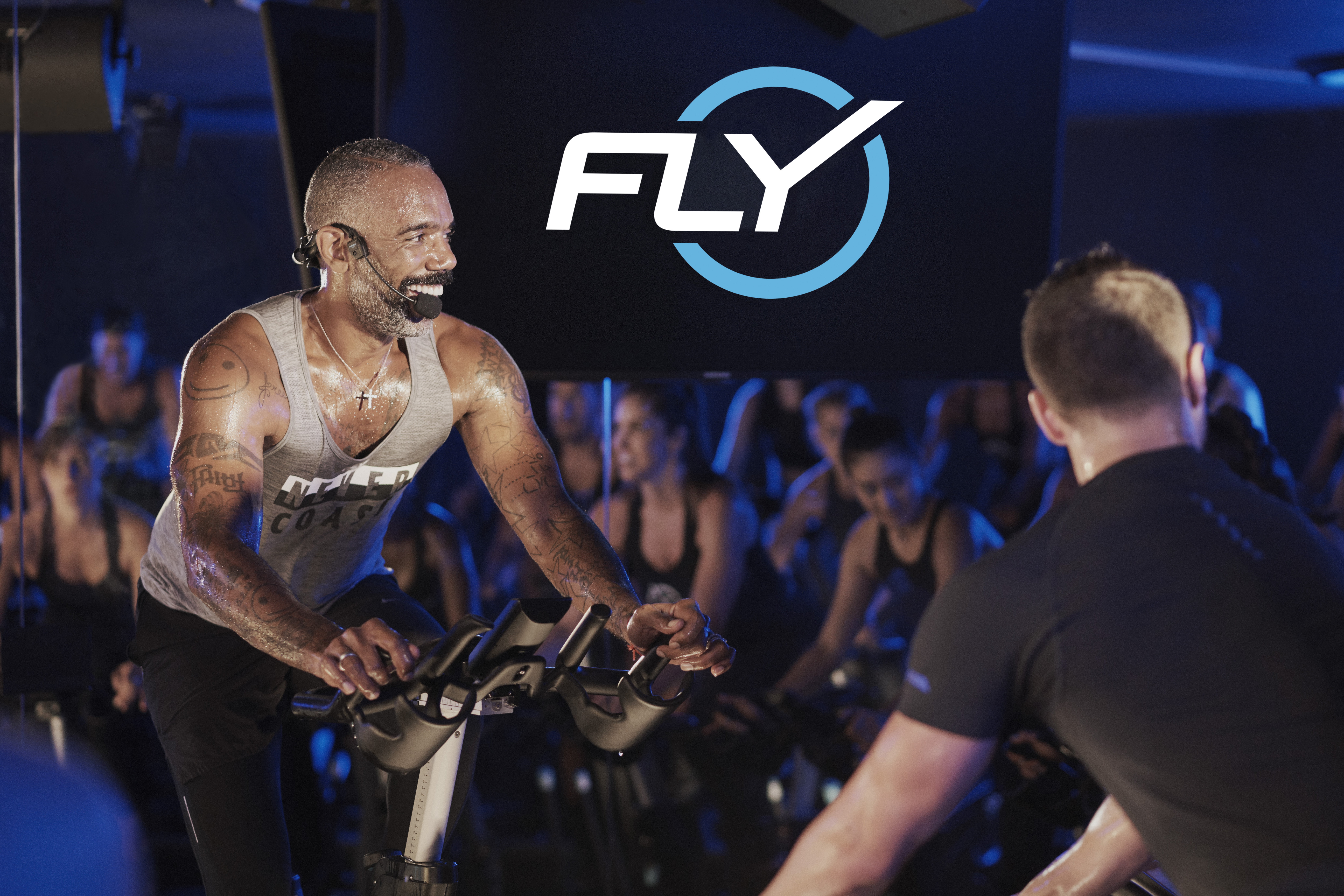 A Male cycling instructor leading a class