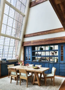 The dining table and large atelier window inside the Greenwich Duplex