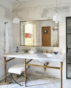 A view of the vanity with a wide mirror and sconces above.