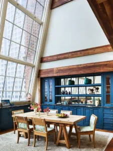 The dining table and large atelier window inside the Greenwich Duplex