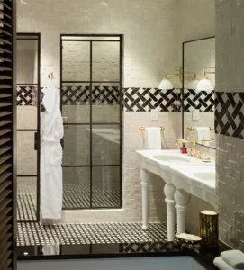 The master bathroom walk-in shower doors, double sink vanity and blue and white tile