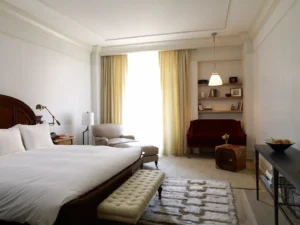 A king bedroom with red sofa and armchair framing the window
