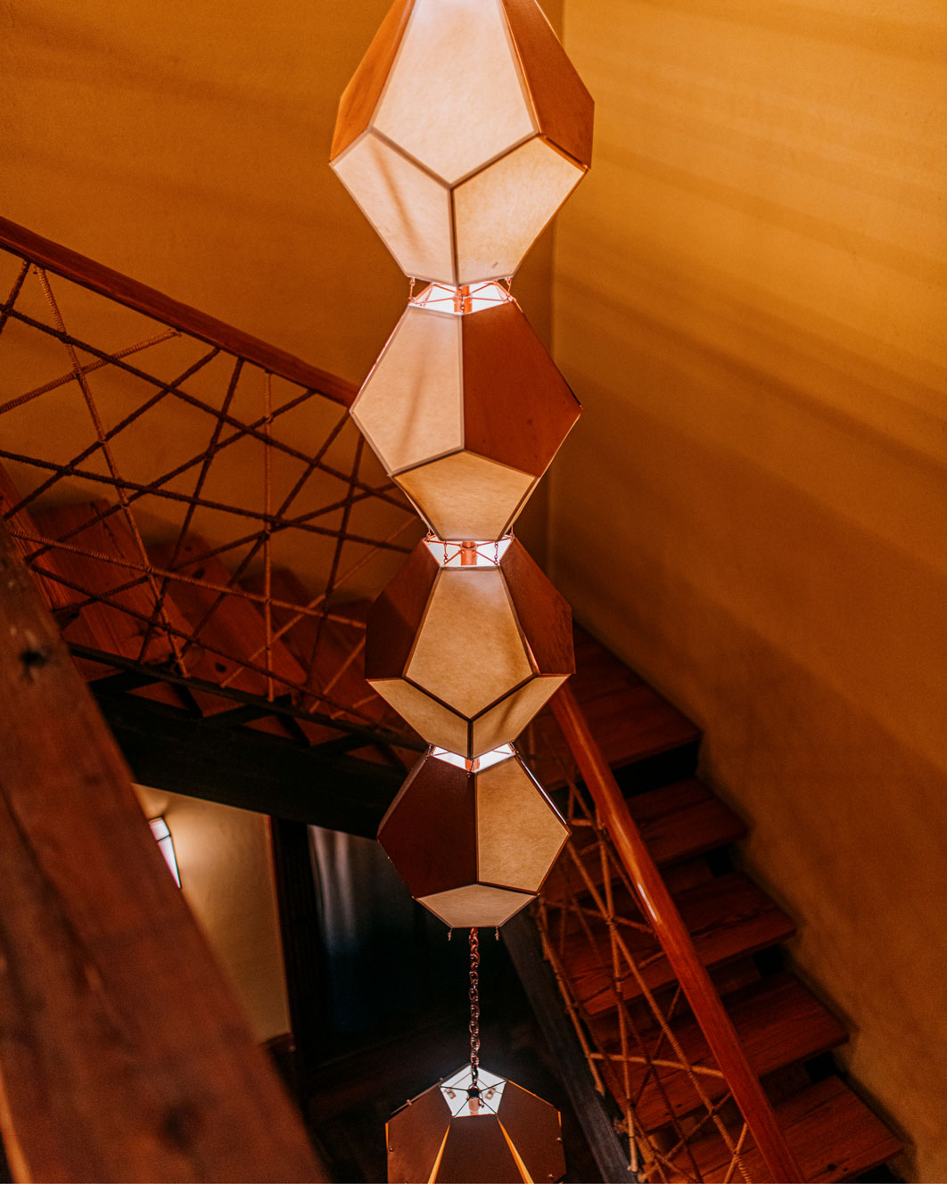 Chandelier in the enter of wooden staircase
