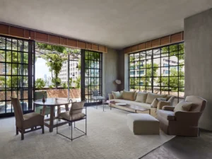 A photo of the naturally lit tribeca penthouse drawing room/seating area with table and chairs, glass doors that open to the balcony and a comfy sofa and chair