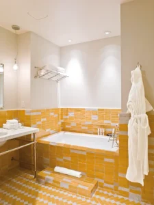 Yellow and white moroccan tile in the bathroom with tub, vanity and robe on the wall