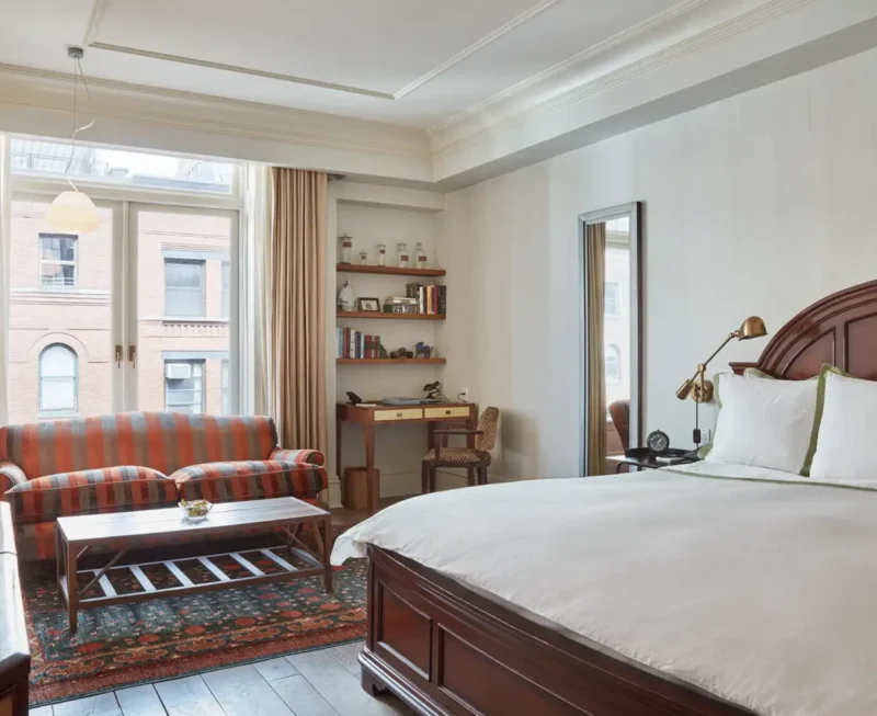 A view of the king bed accessible room. Bright natural light with seating area, desk, bed and tv.