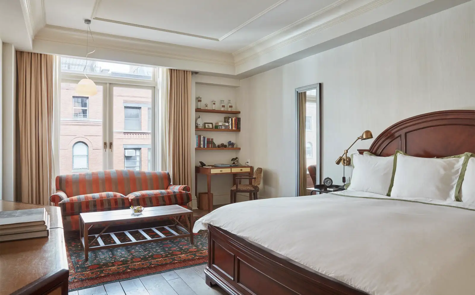 A view of the king bed accessible room. Bright natural light with seating area, desk, bed and tv.
