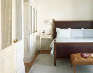 Two bedroom corner suite primary bed room with large closest space, a rug, side table and large king bed