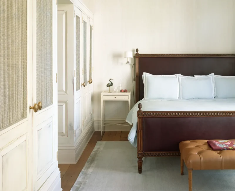 Two bedroom corner suite primary bed room with large closest space, a rug, side table and large king bed