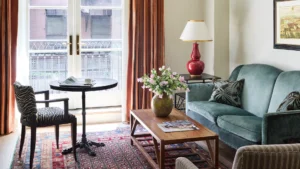 Glass balcony doors letting natural light flood the small dining table, sofa and coffee table in the living area.