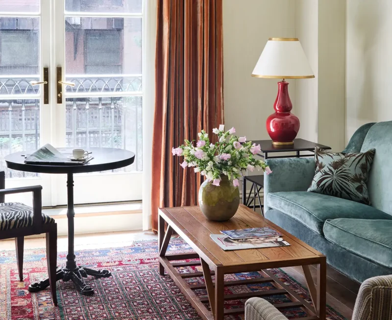 Glass balcony doors letting natural light flood the small dining table, sofa and coffee table in the living area.