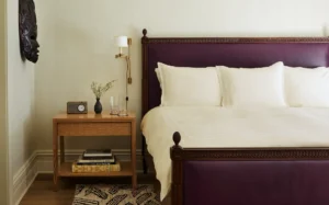 courtyard suite bedroom Bed and side table view with a decorative mask on the wall