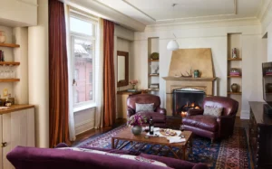 Fireplace Corner suite living room sofa and leather arm chairs with large window and fireplace in the background