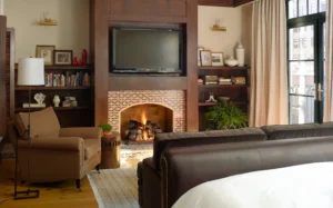Inside the master bedroom looking at the fireplace with tv mounted above