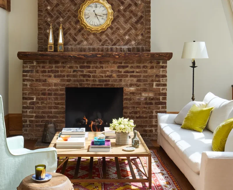 The Greenwich duplex fireplace sitting area with a white sofa, coffee table, arm chair and 30ft tall windows letting in a lot of natural light