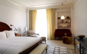 A king bedroom with red sofa and armchair framing the window