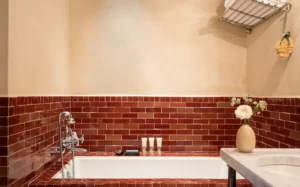 A view of red moroccan tile surrounding a soaking tub in a courtyard suite bathroom
