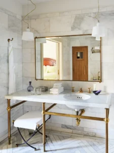 A view of the vanity with a wide mirror and sconces above.