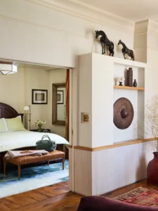 Looking from the living room through the door to catch a glance of the bed inside the bedroom.