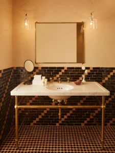 Bathroom with blue and white moroccan tile looking directly at the marble vanity, mirror and pendant lighting