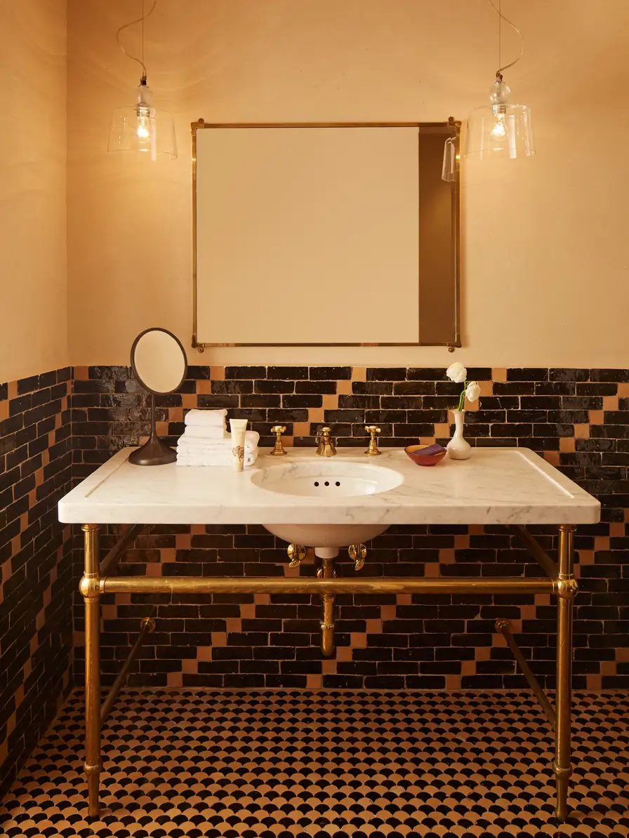 Bathroom with blue and white moroccan tile looking directly at the marble vanity, mirror and pendant lighting