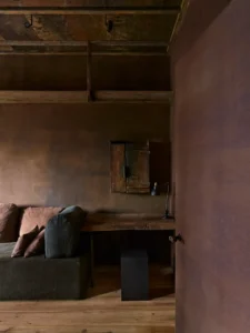 The second bedroom with red tones and a seating area